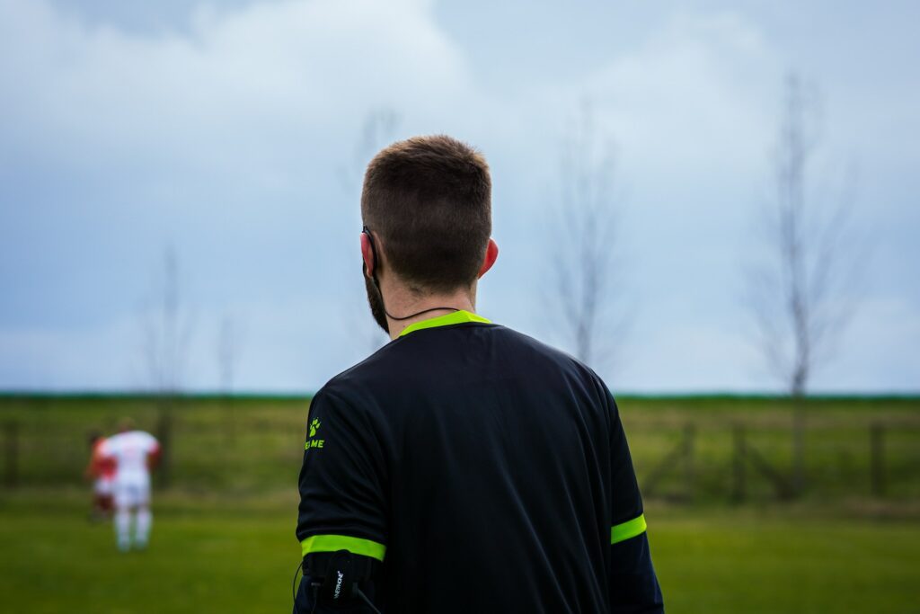 a man wearing a cold weather soccer gear contemplating on his next move on the field. Photo by nygi via www.unsplash.com