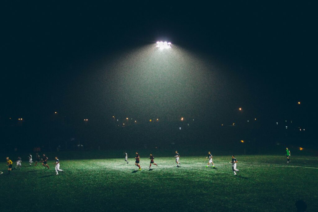 While soccer uses two halves, a rainy night game under stadium lights might make new fans ask how many quarters in soccer. Image by Abigail Keenan via www.unsplash.com